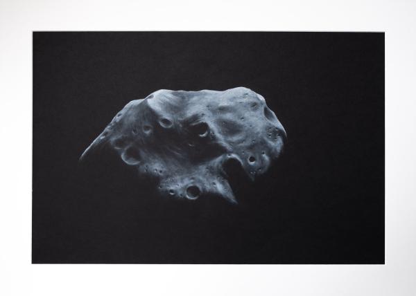 black and white asteroid named Lutetia, with little light from above on black background